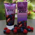 SWEETBODZ Mixed Berry Body Lotion 180ml featuring body lotion, product packaging and fresh mixed berries

